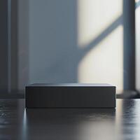 A black box sitting on a table in front of a window photo