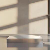 A silver box sitting on a table in front of a window photo