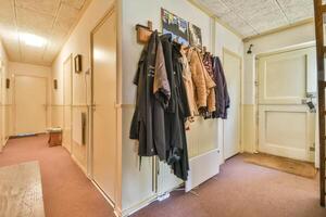 A hallway with coats hanging on a coat rack photo