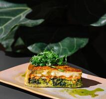 Delicious slice of quiche with salmon and spinach resting on plate photo
