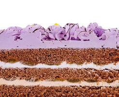 Delicious purple birthday cake with butter cream and chocolate topping being cut in half photo