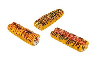 Three sushi rolls covered in sauce and sesame seeds floating on white background photo
