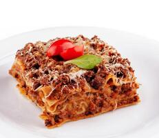 Portion of lasagna sitting on a white plate photo