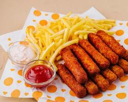 Breaded mozzarella sticks with french fries and dipping sauces photo