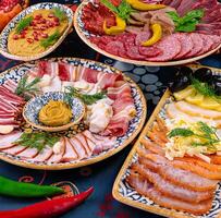 Plates with different appetizers being placed on the table for guests photo