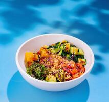 White bowl presenting colorful hawaiian style poke bowl with salmon and mango photo
