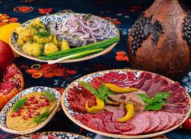 Table is set with plates of meat, fish, and sauce photo
