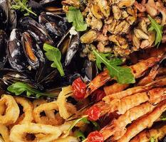 Delicious array of assorted seafood, including prawns, mussels, and calamari photo
