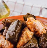 Delicious stuffed grape leaves and cabbage rolls presenting a traditional balkan dish photo