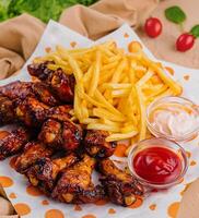 Bbq chicken wings with french fries and dips photo
