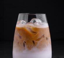 Iced coffee latte with milk and boba tapioca pearls standing on black background photo