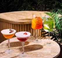Four colorful cocktails resting on a table in a tropical setting photo