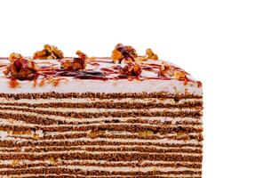 Delicious cake topped with walnuts and caramel drizzle on white background photo