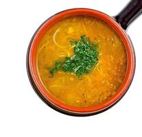 Chicken soup with noodles and carrots being served in a bowl photo