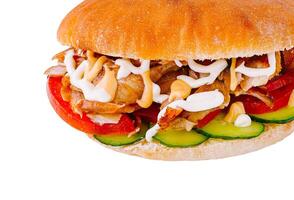 Doner kebab sandwich is lying on a white surface and showing its ingredients photo