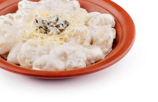 Gnocchi topped with blue cheese and parmesan are served on a plate photo
