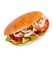 Doner kebab sandwich is lying on a white surface and showing its ingredients photo