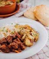 Delicious beef stew served with roasted potatoes and fresh coleslaw salad photo