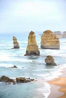 View of the 12 Apostles in cloudy day, Erosion of the mainland coast's limestone cliffs on The Great Ocean Road is an Australian National Heritage-listed at south-eastern coast of Victoria, Australia photo