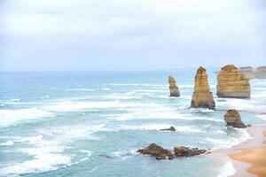 View of the 12 Apostles in cloudy day, Erosion of the mainland coast's limestone cliffs on The Great Ocean Road is an Australian National Heritage-listed at south-eastern coast of Victoria, Australia photo