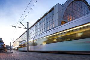 Tram Approaches Alexanderplatz Station at Twilight in Berlin photo