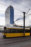 Tram Passing by Park Inn Hotel Against a Cloudy Sky in Berlin Mitte photo