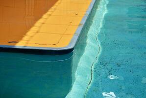 Blue water pool surface isolated on horizontal ratio yellow floor background. photo