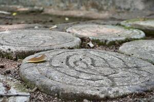 Close up texture on round shaped rock stepping stone walk way path isolated on horizontal ratio outdoor park environment background. photo
