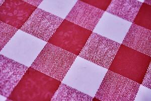Red and white square checkered fabric table top pattern material isolated on horizontal ratio full frame background. photo
