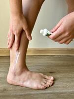 Applying moisturizing cream by hand to a healing scar on the right ankle with tube cream photo