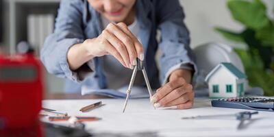 Architect Using a Compass for Precise Blueprint Design in Construction Planning photo