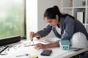 Engineer using compass for precise drafting in office photo