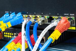 Network hub with LAN cable connected to patch cables connected to internet data center photo