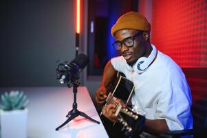 african american man with guitar in recording studio photo