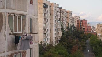 Laundry is being air-dried on ropes strung in front of windows of a multi-story building that is representative of the Soviet-era architecture. This building houses low-income citizens. video