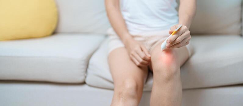 Arthritis and Muscle Pain Relief Cream concept. woman having knee ache and muscle pain due to Runners Knee or Patellofemoral Pain Syndrome, osteoarthritis, rheumatism and Patellar Tendinitis photo
