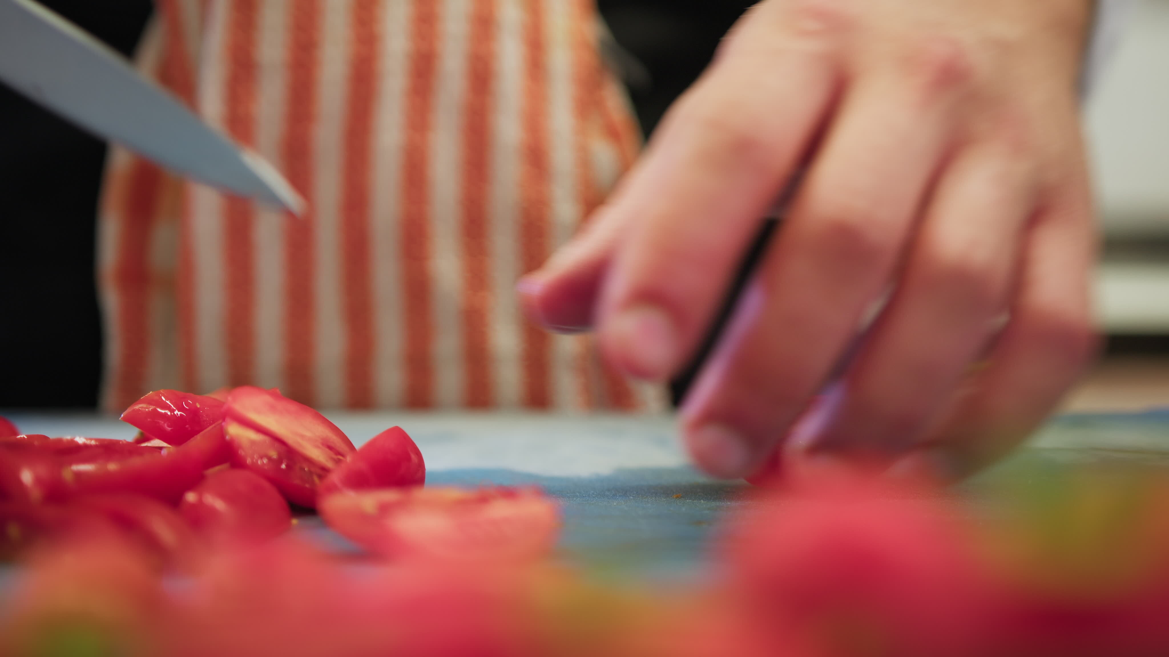 Chef Prepares The Line In The Kitchen By Cutting Seasonal Red Tomatoes
