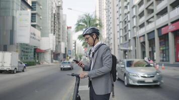 A man in a suit and helmet using his phone while riding an electric scooter video
