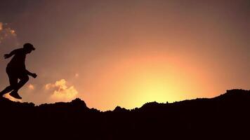 A man is running up a mountain at sunset video