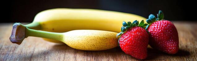 Fresh bananas and strawberries arranged on a wooden table photo