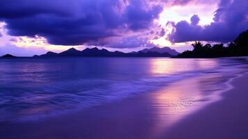 Tropical beach at dusk with tranquil waves and distant mountains photo