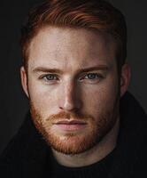 Close-up of a red-haired man with blue eyes on a dark background photo