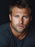 Close-up portrait of a man with striking blue eyes and short hair photo