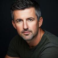 Portrait of a mature man with short gray hair in a dark setting photo