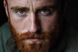 Close-up portrait of a man with striking green eyes and red beard photo
