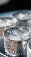 Refreshing cold drinks served in metal cups with ice on a sunny day photo