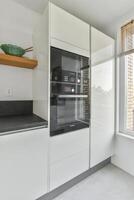 A kitchen with a large window and a white cabinet photo