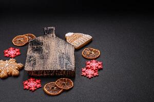 Empty wooden cutting board with copy space with gingerbread cookies and Christmas decor photo