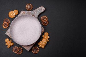 Empty round ceramic copy space plate with gingerbread cookies and Christmas elements photo