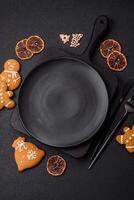 Empty round ceramic copy space plate with gingerbread cookies and Christmas elements photo